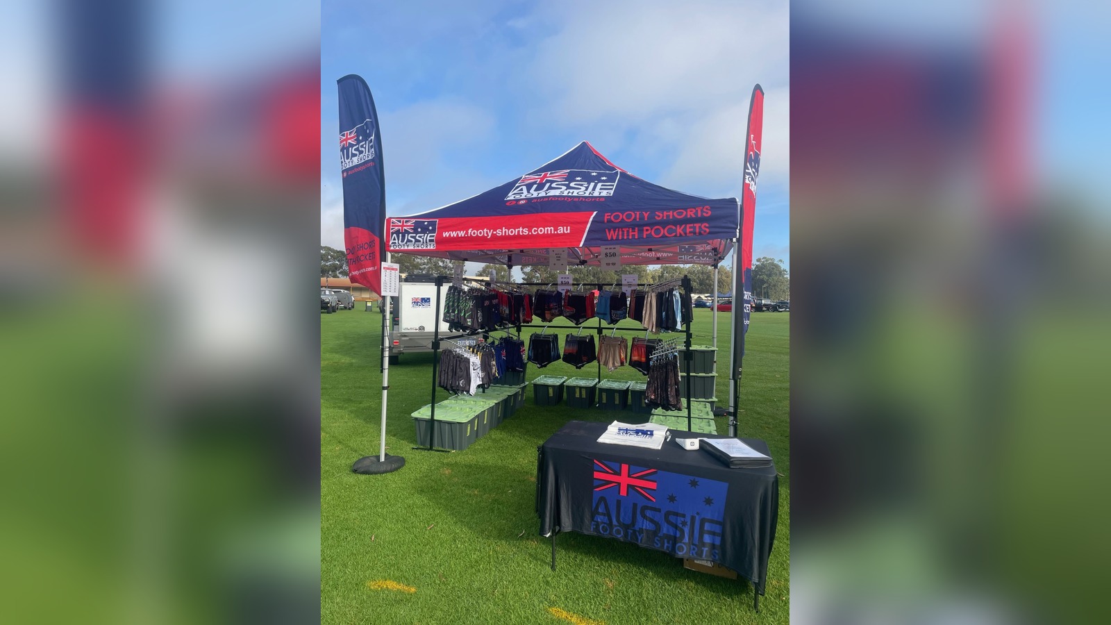 Aussie Footy Shorts marquee with Australian flag branding and "Footy Shorts With Pockets" signage