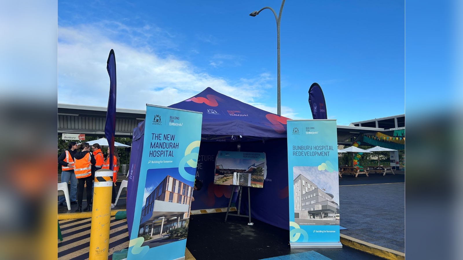 Building for Tomorrow marquee with pull-up banners for "The New Mandurah Hospital" and "Bunbury Hospital Redevelopment"
