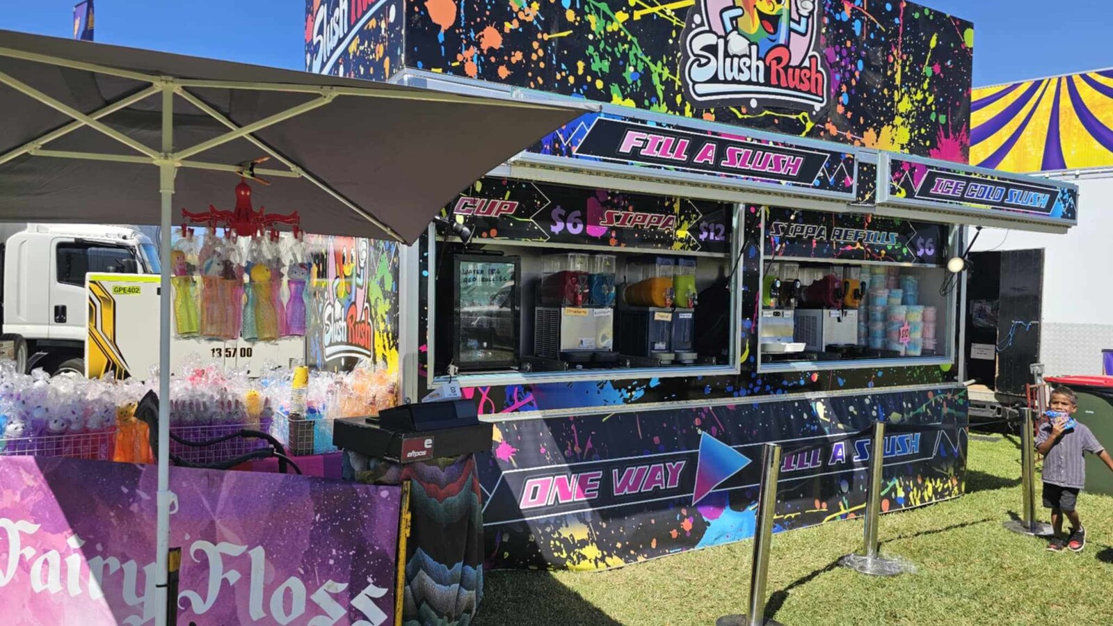 Slush Rush food trailer with bright paint-splatter graphics and cartoon slushie mascot
